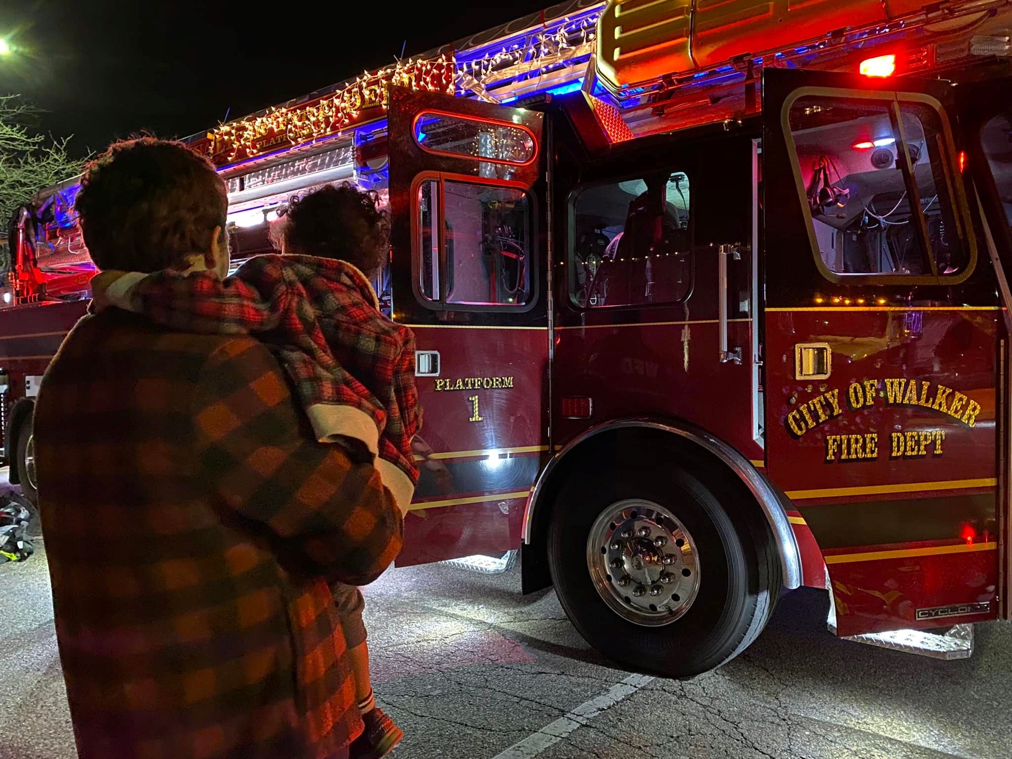 Family standing in front of decorated fire truck