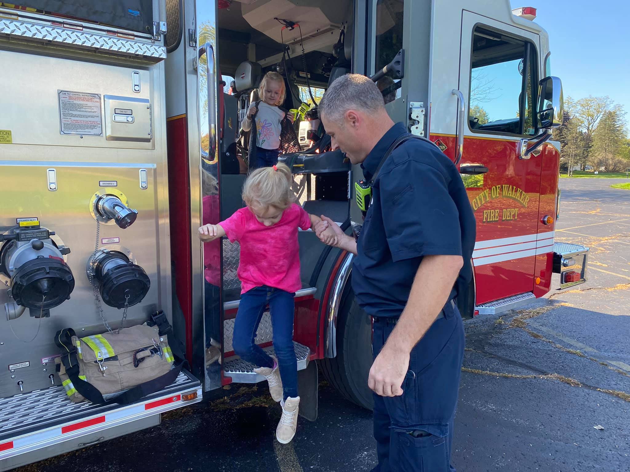 Firefighter helps girl out of fire truck