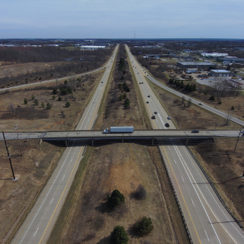 Drone shot of highway with bridge crossing over it.